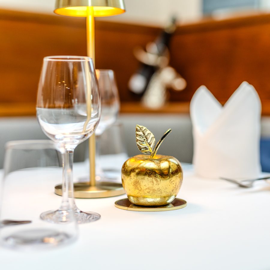 Gedeckter Tisch mit goldenem Apfel